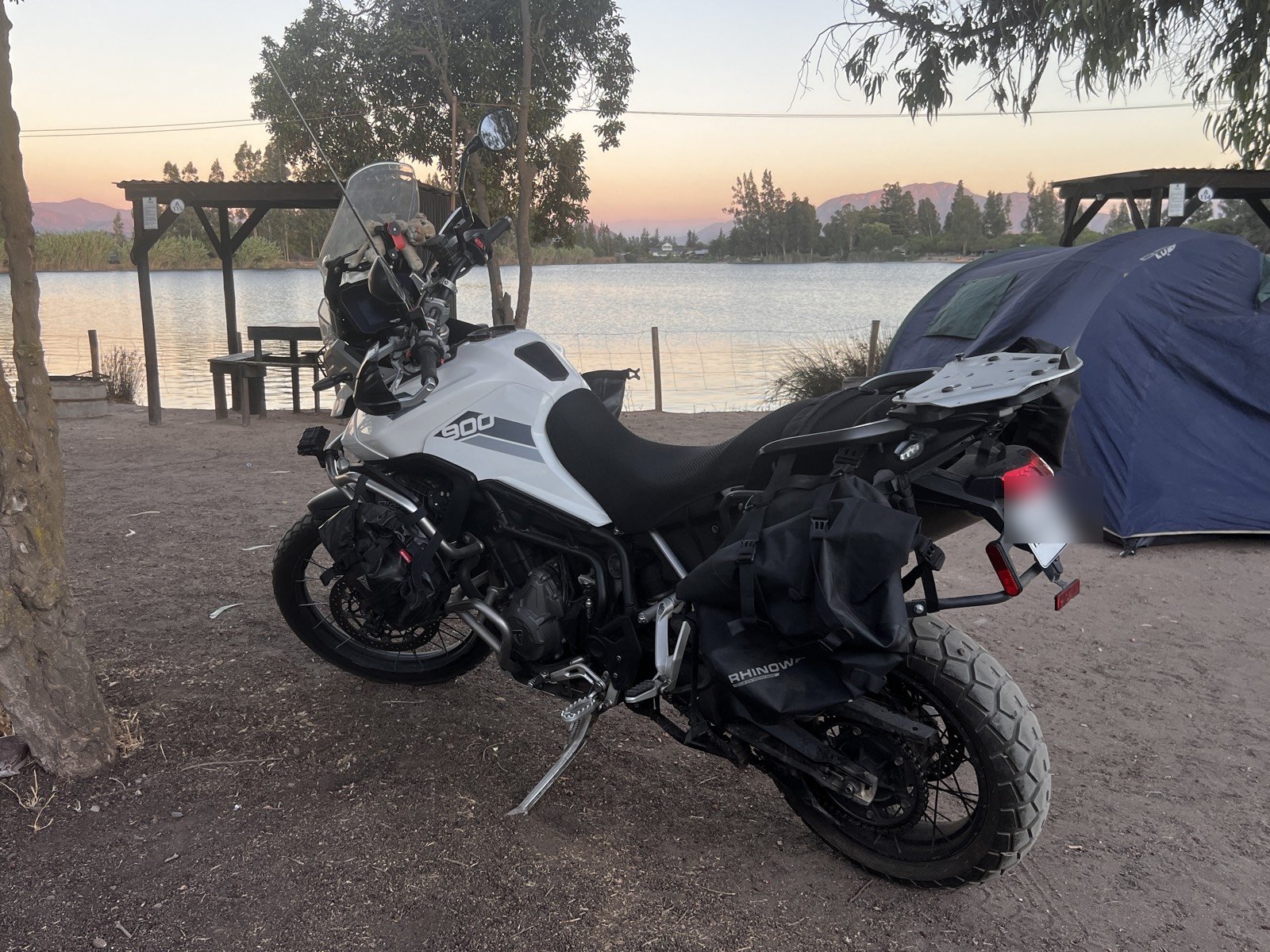 Moto junto a un lago al atardecer, acampando