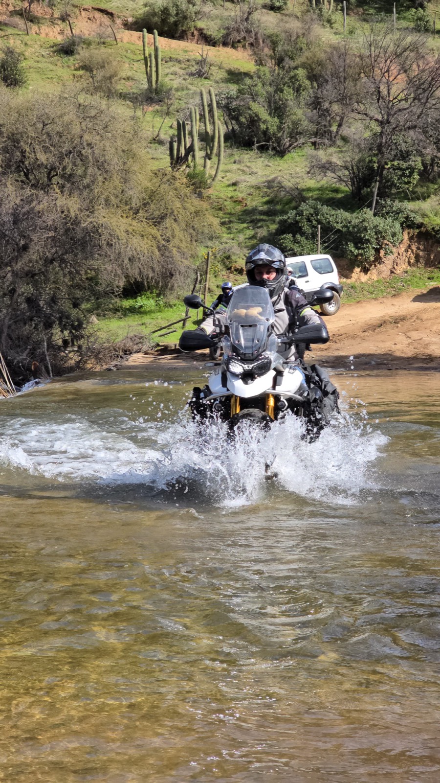 Cruzando un río en moto por un camino de tierra