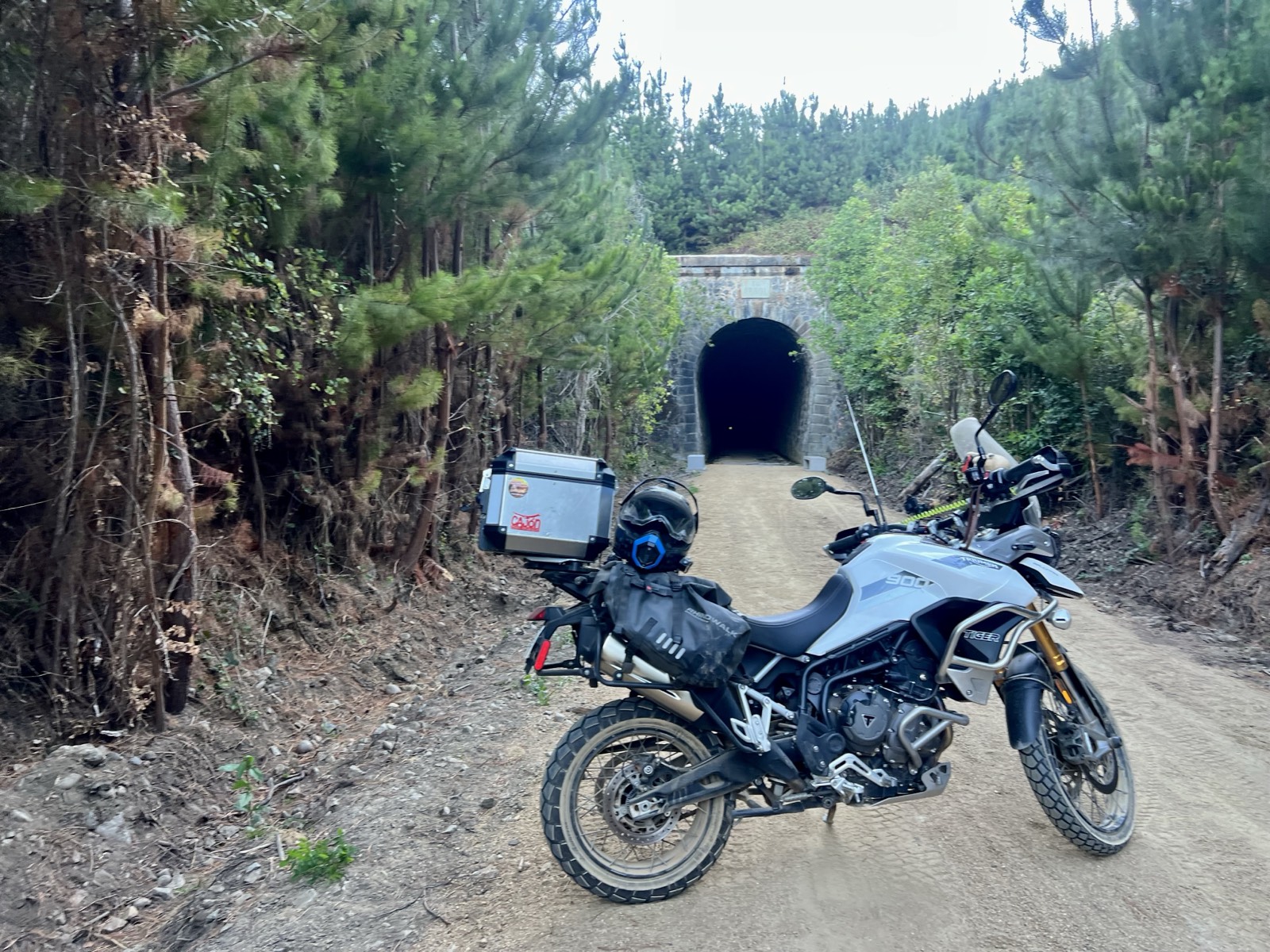 Moto frente a la entrada de un túnel de piedra